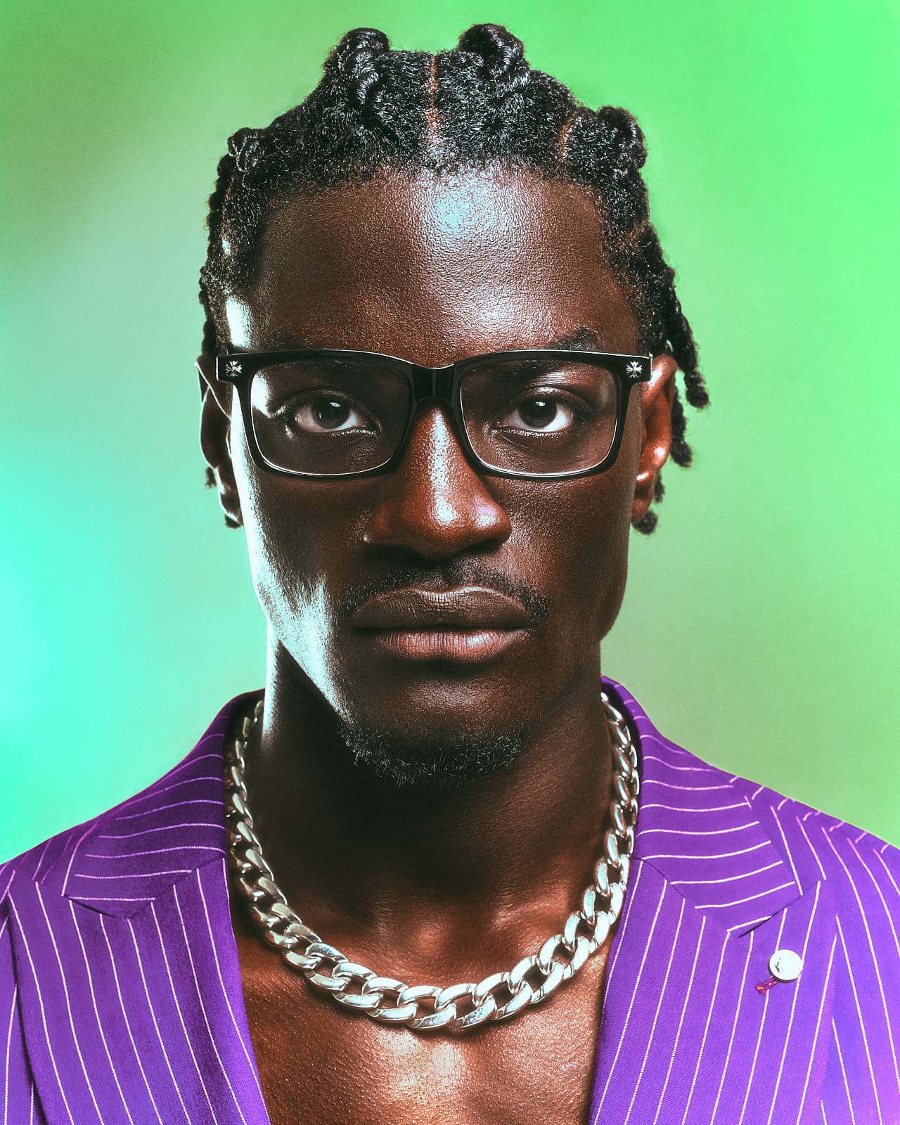 Ibo in a purple pinstripe suit with a silver chain
