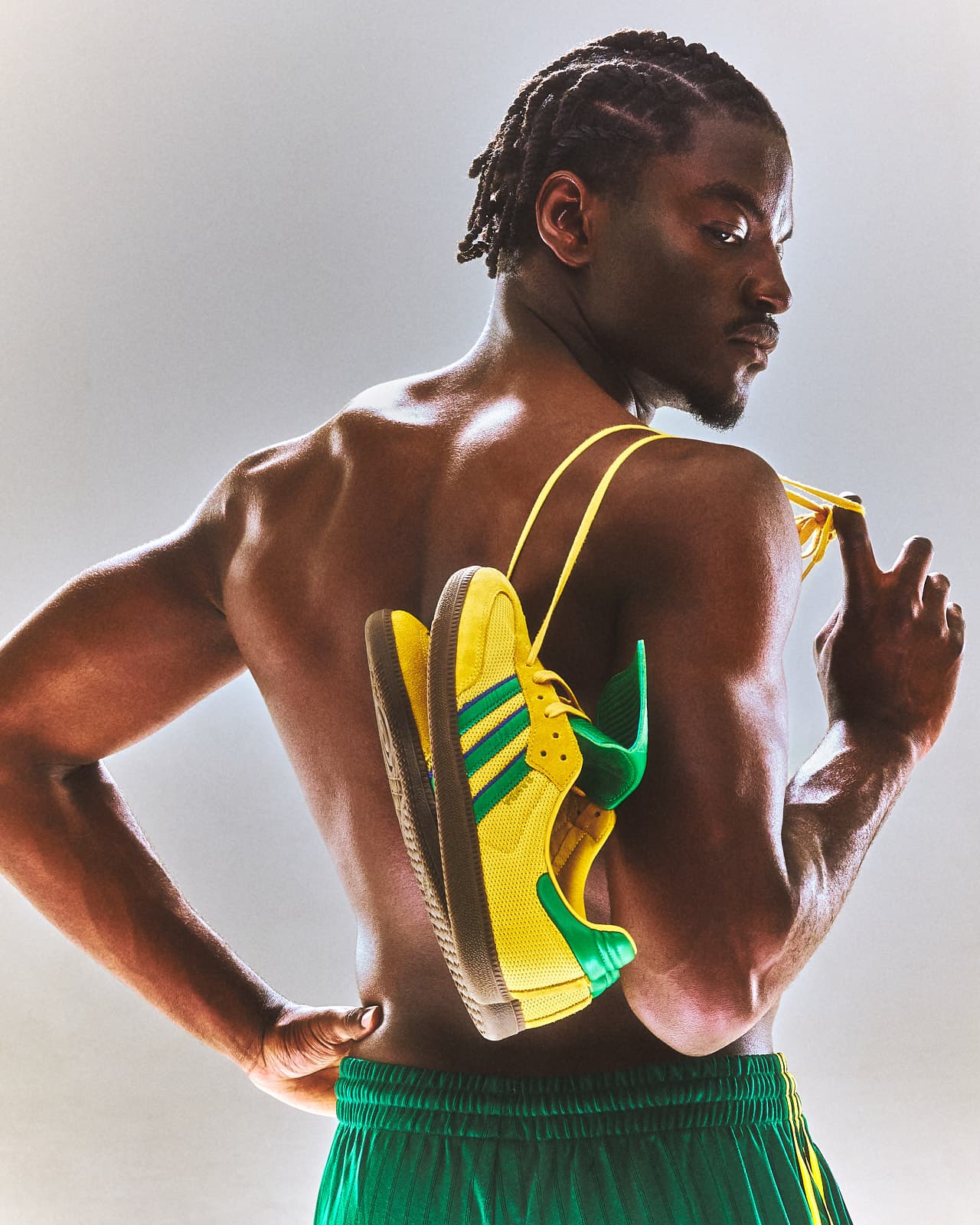 Ibo from behind, yellow sneakers slung over his shoulder