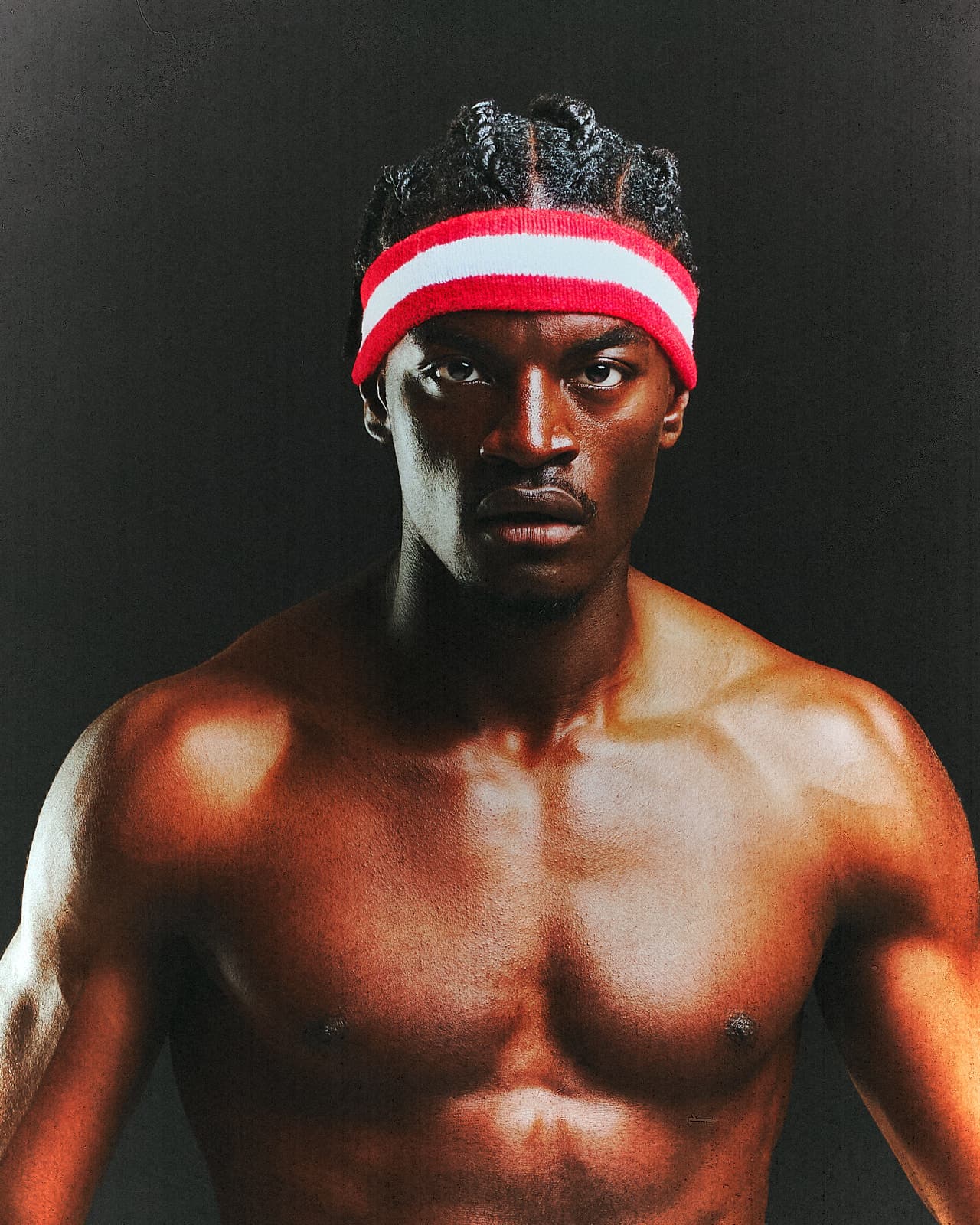 Ibrahim “Ibo” Ouro-Bodi — frontal portrait in a dark studio, intense direct gaze